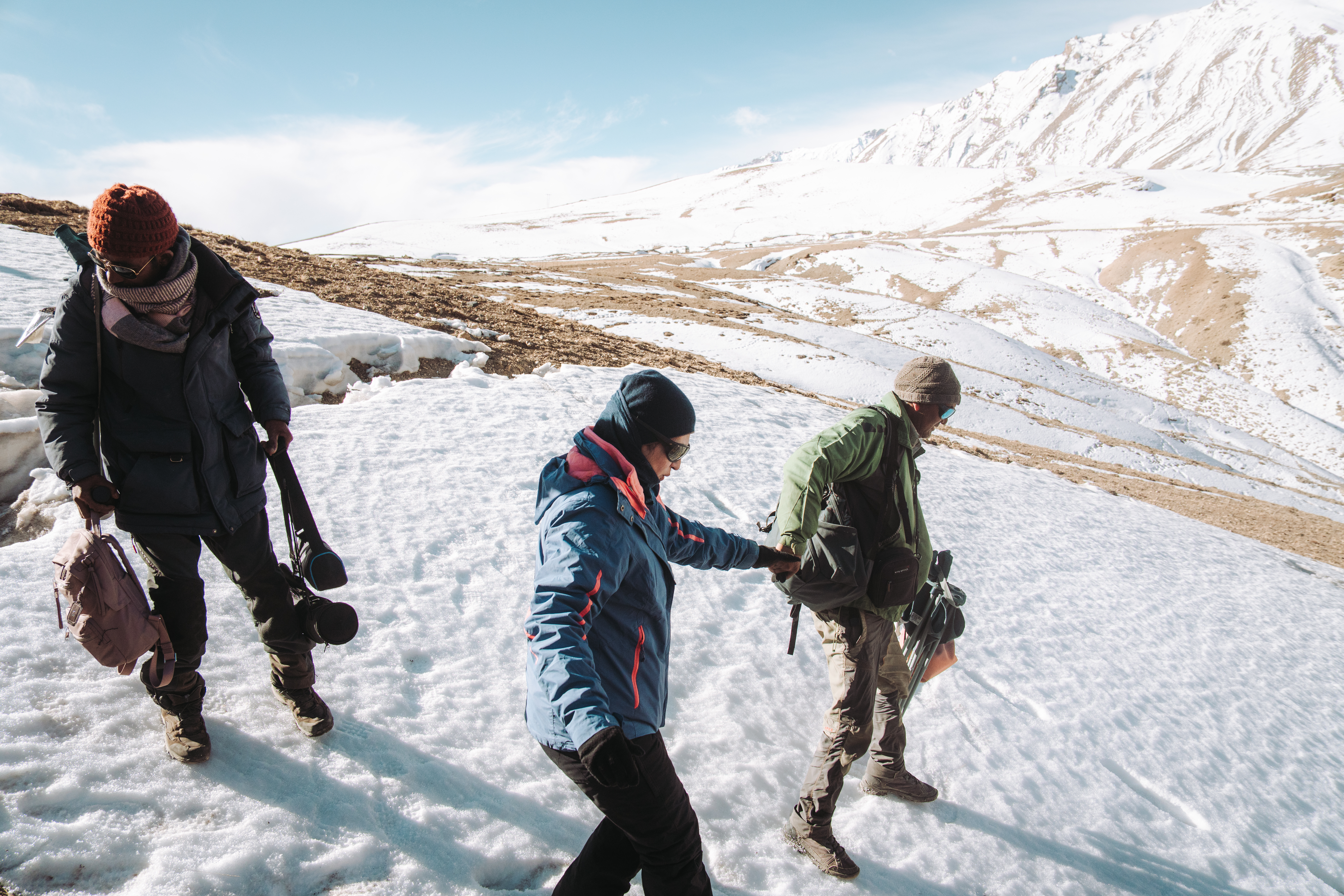A group of Just Nature guests using spotting scopes and telephoto lenses during a snow leopard expedition in Spiti Valley.