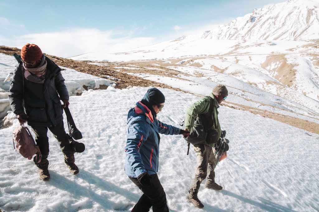 Just Nature guests crossing a snowfield during a snow leopard tracking expedition in the high Himalayas